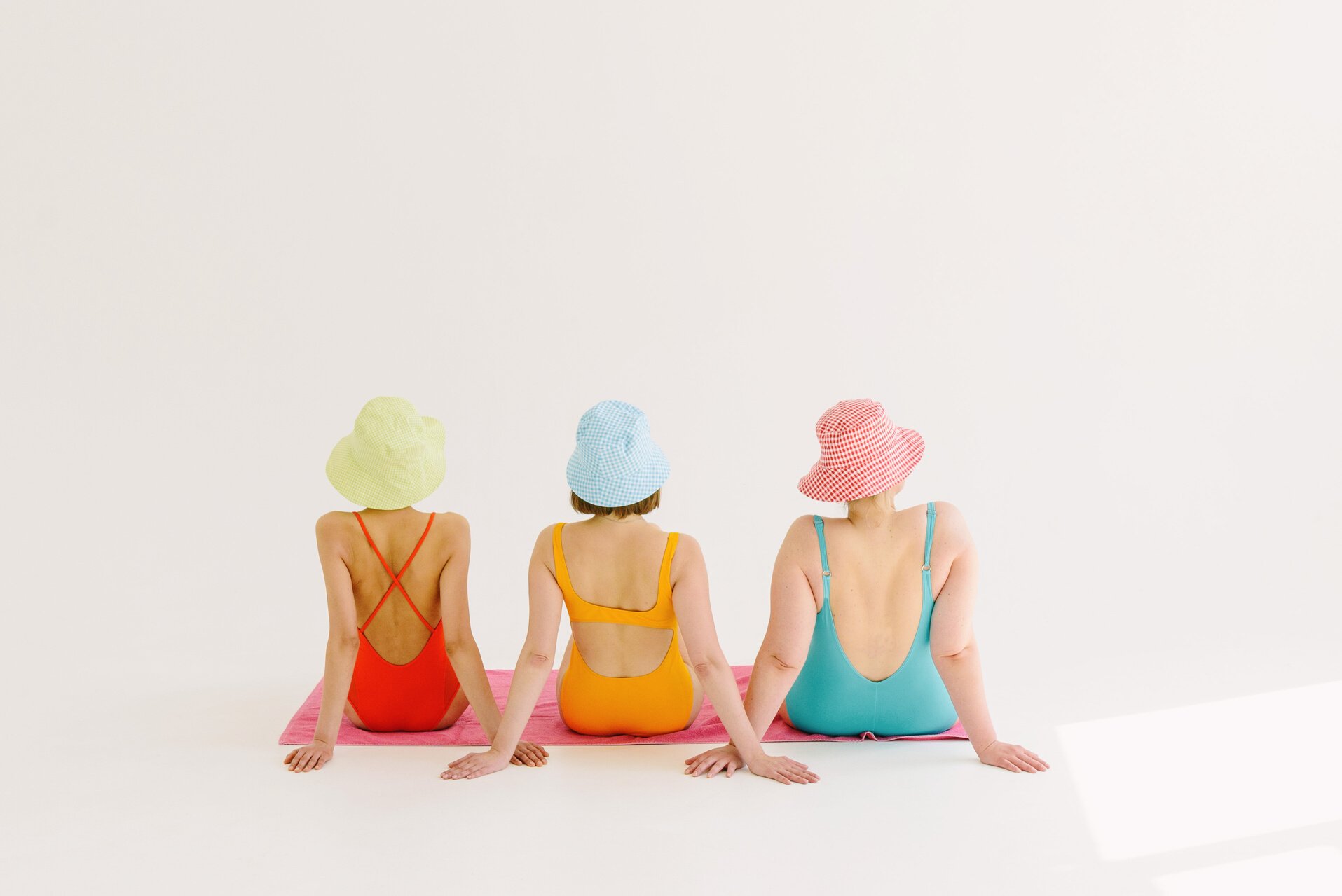 Women Wearing Colorful Swimsuits and Hats